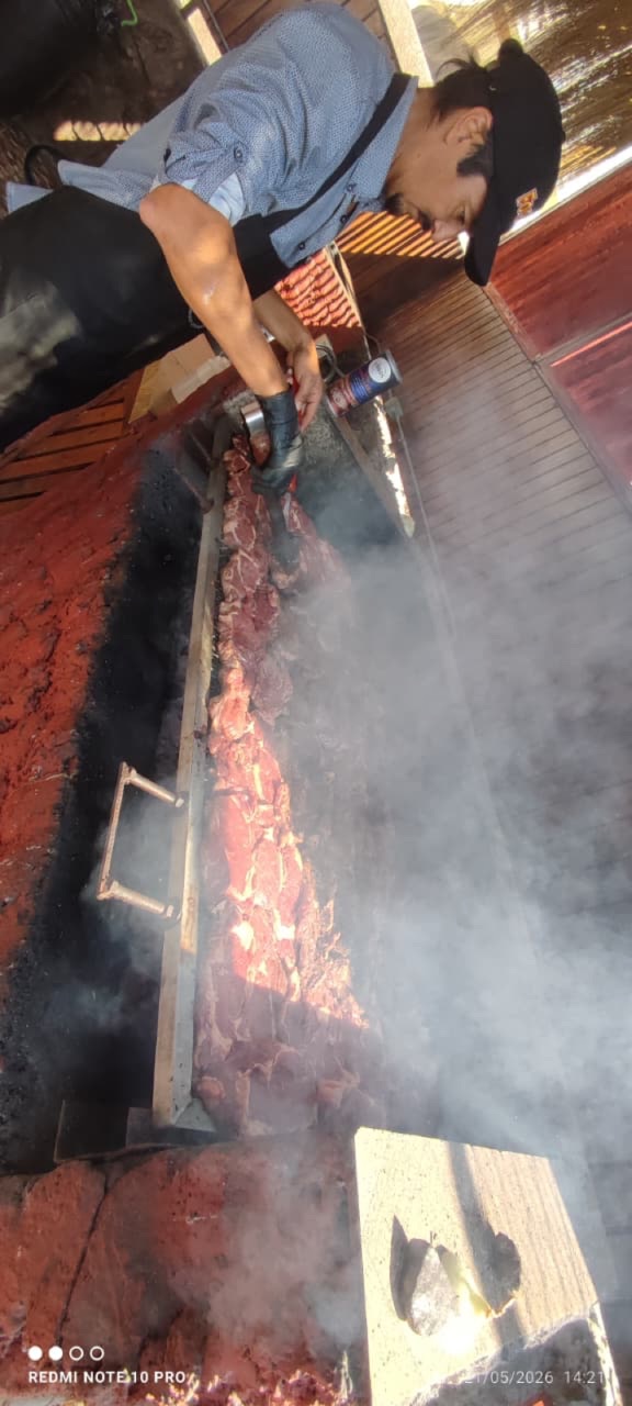 Parrillero de Fogones preparando carnes a las brasas durante un evento